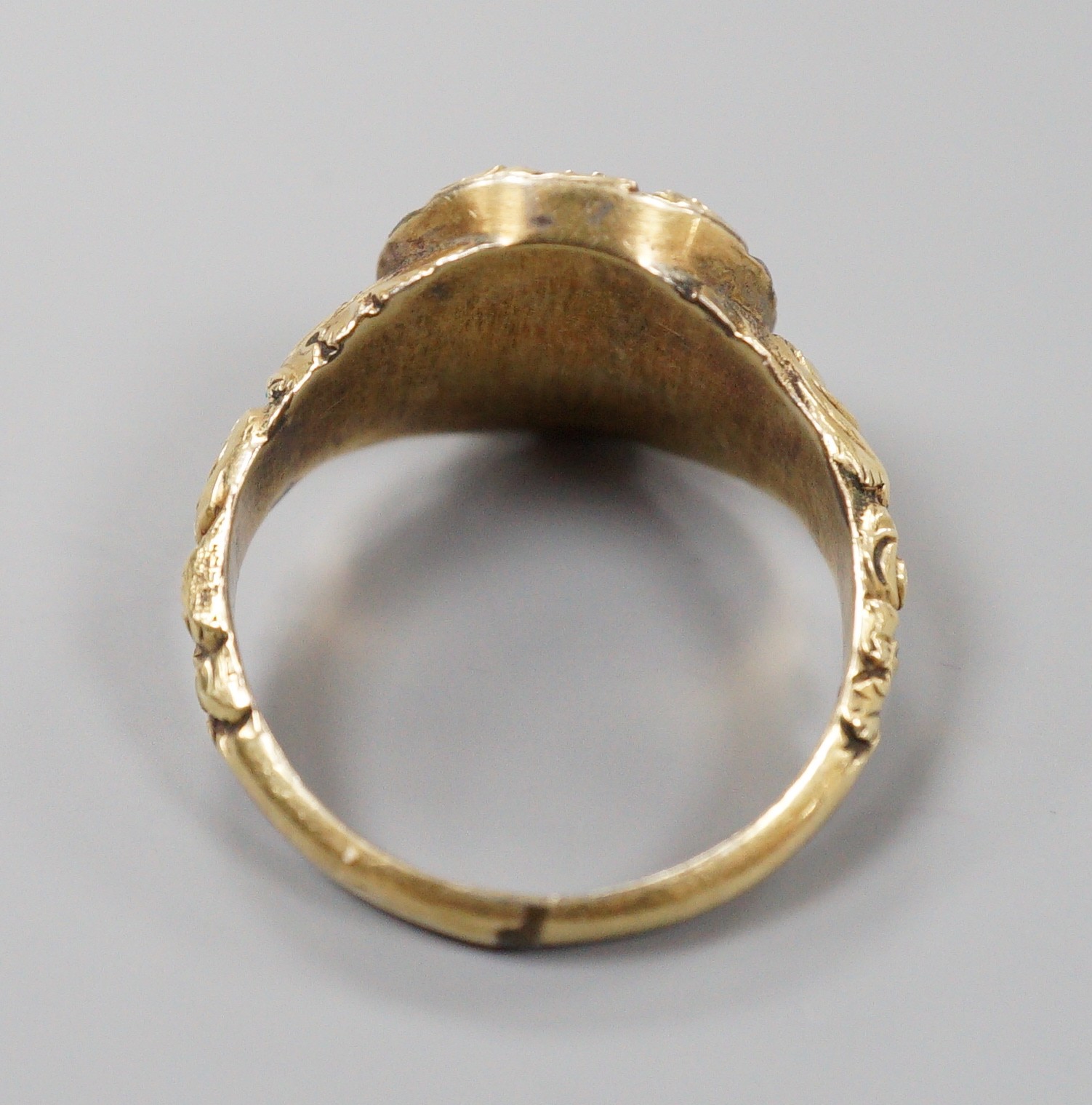A Georgian yellow metal and foil backed quartz set oval ring, with carved setting and shoulders, size S/T, gross weight 6.4 grams.
